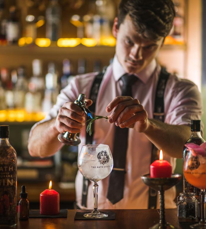 A person preparing a gin cocktail.