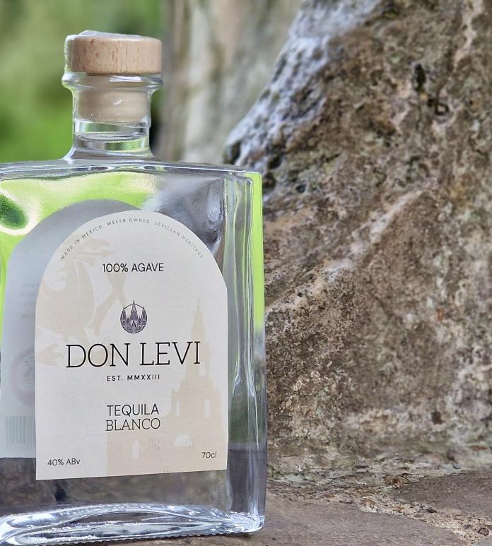 Bottle of tequila sitting on a rock