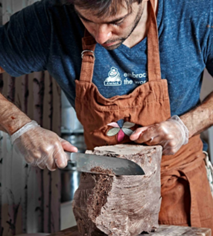 a man carving a large chocolate block