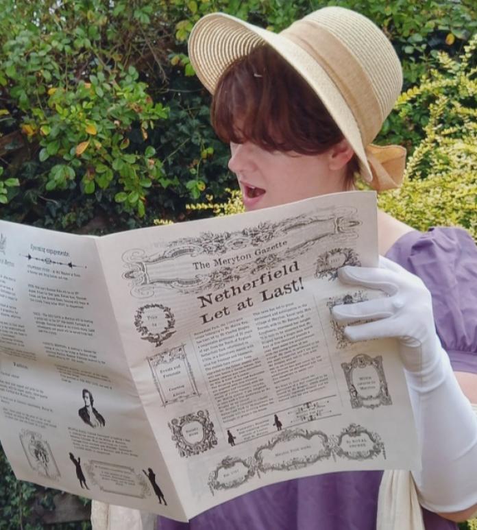 regency dressed lady reading a paper