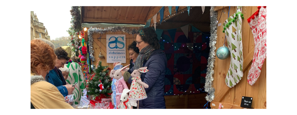 A group of ladies looking at products for sale by Alzheimer's society