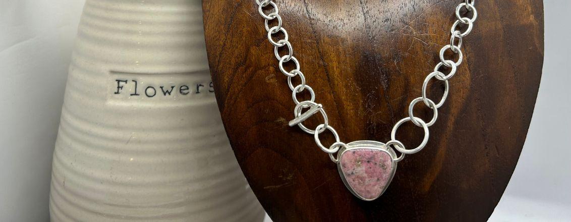 A silver necklace with a heart pendant