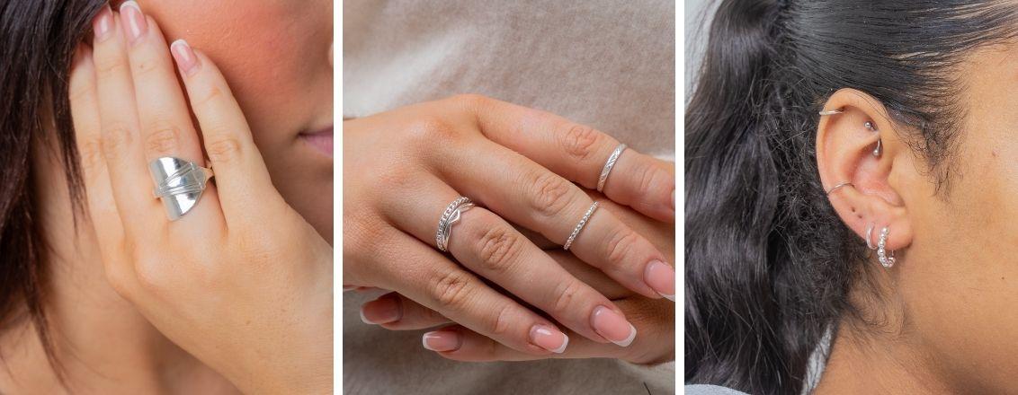 Close-up image of silver rings and earrings, modelled. 