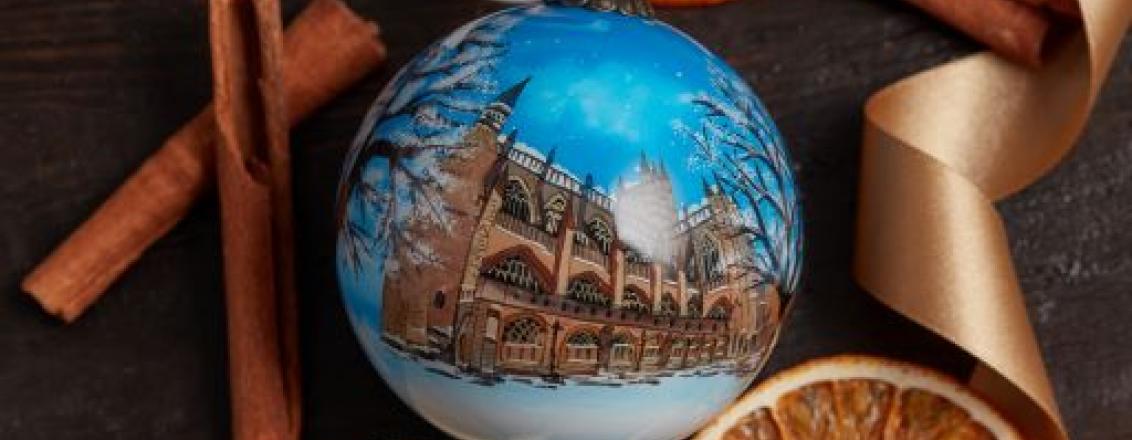 hand painted bauble on a bed of dried orange and cinnamon sticks 